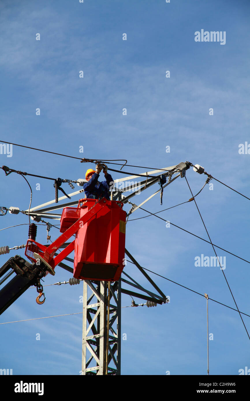 Electrician working on top of a pylon Stock Photo