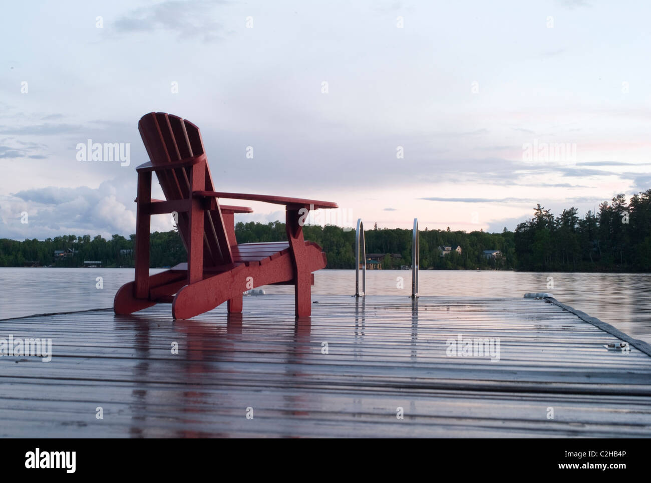 Lake Of The Woods, Ontario, Canada; Empty Deck Chair On A Pier Next To A Lake Stock Photo