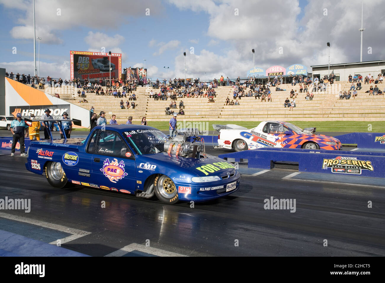 Two heavily modified and supercharged Australian Holden ute drag racing cars line up to race on the quarter mile drag strip Stock Photo