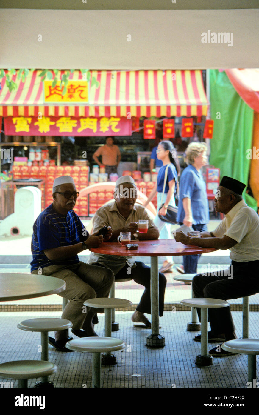 Three elderly retired men drink coffee at a Singapore Food Court coffee shop Stock Photo Alamy