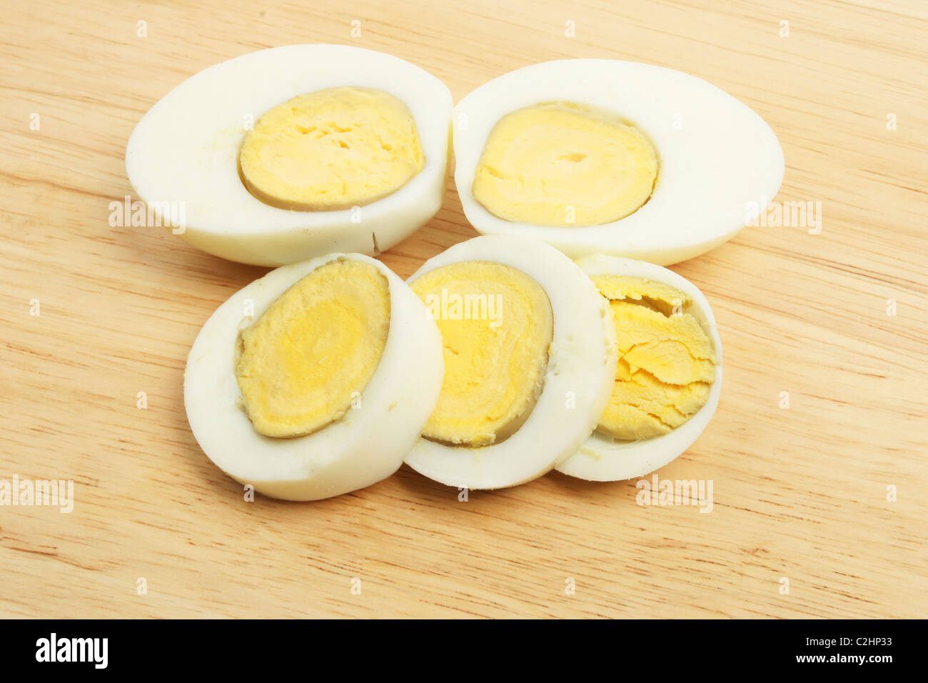 Sliced hard boiled eggs on a wooden board Stock Photo