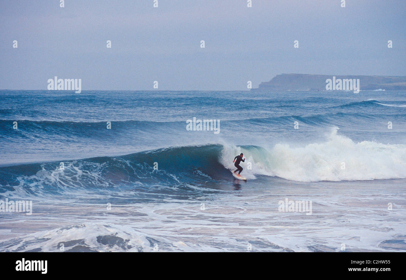 Surfer riding a wave at East Strand, Portrush, County Antrim, Northern Ireland. Stock Photo