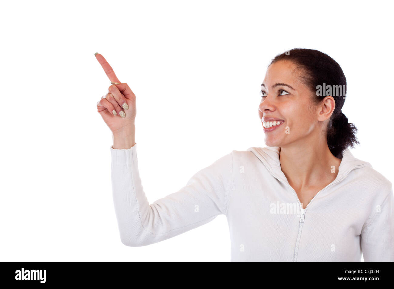 Beautiful, dark skinned woman pointing happy with finger at copyspace. Isolated on white background. Stock Photo