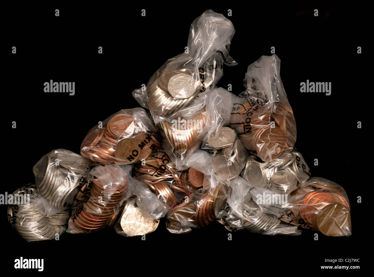 Pile of sterling coins in money bags studio cutout Stock Photo