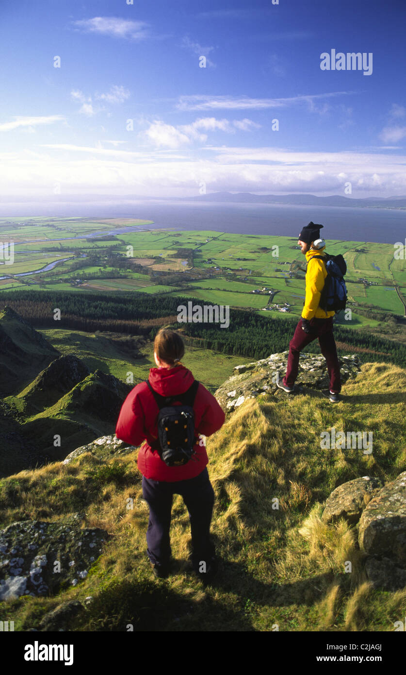 Walkers looking over Magilligan Point from the summit of Binevenagh, County Derry, Northern Ireland. Stock Photo