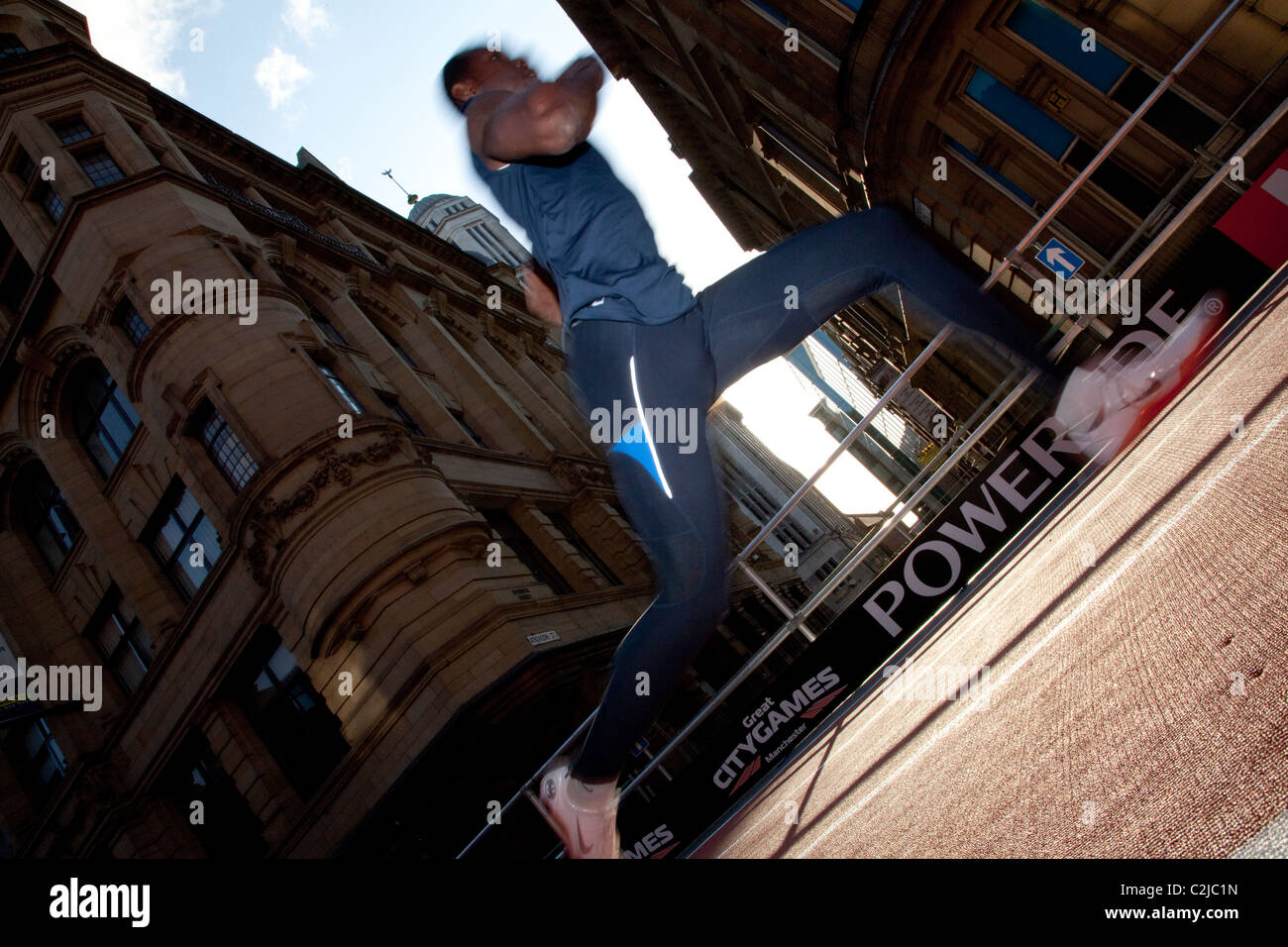 A sprinter framed by the sun on Deansgate, Manchester, as he warms up for the Great City Games 2010, on a temporary track. Stock Photo