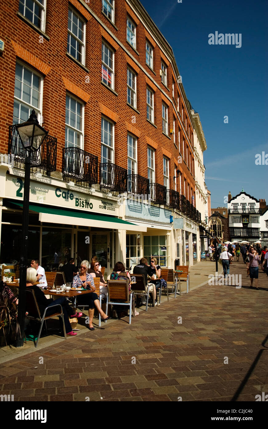 People sitting at tables outside a Café opposite Exeter Cathedral, Exeter, Devon England UK 2011 Stock Photo