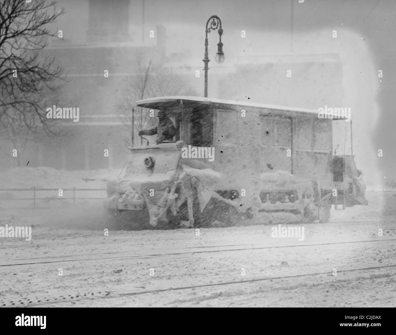 Trolley Snowplow Pushes ahead in heavy snowfall on New York Streets Stock Photo