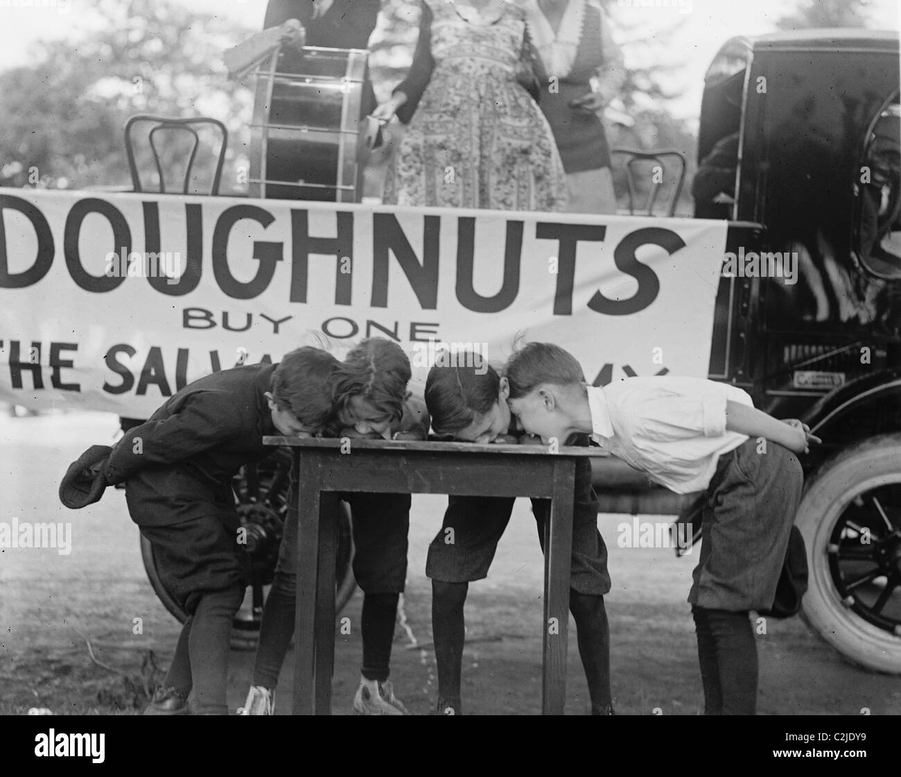 Boys Chow Down on a Table in a Donut Eating Contest Stock Photo