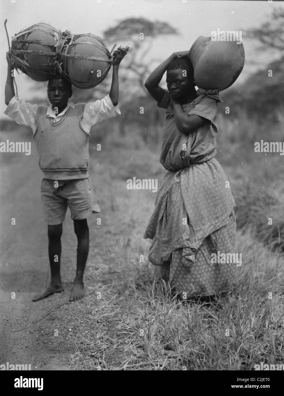 Uganda boy and girl carrying jars Stock Photo - Alamy