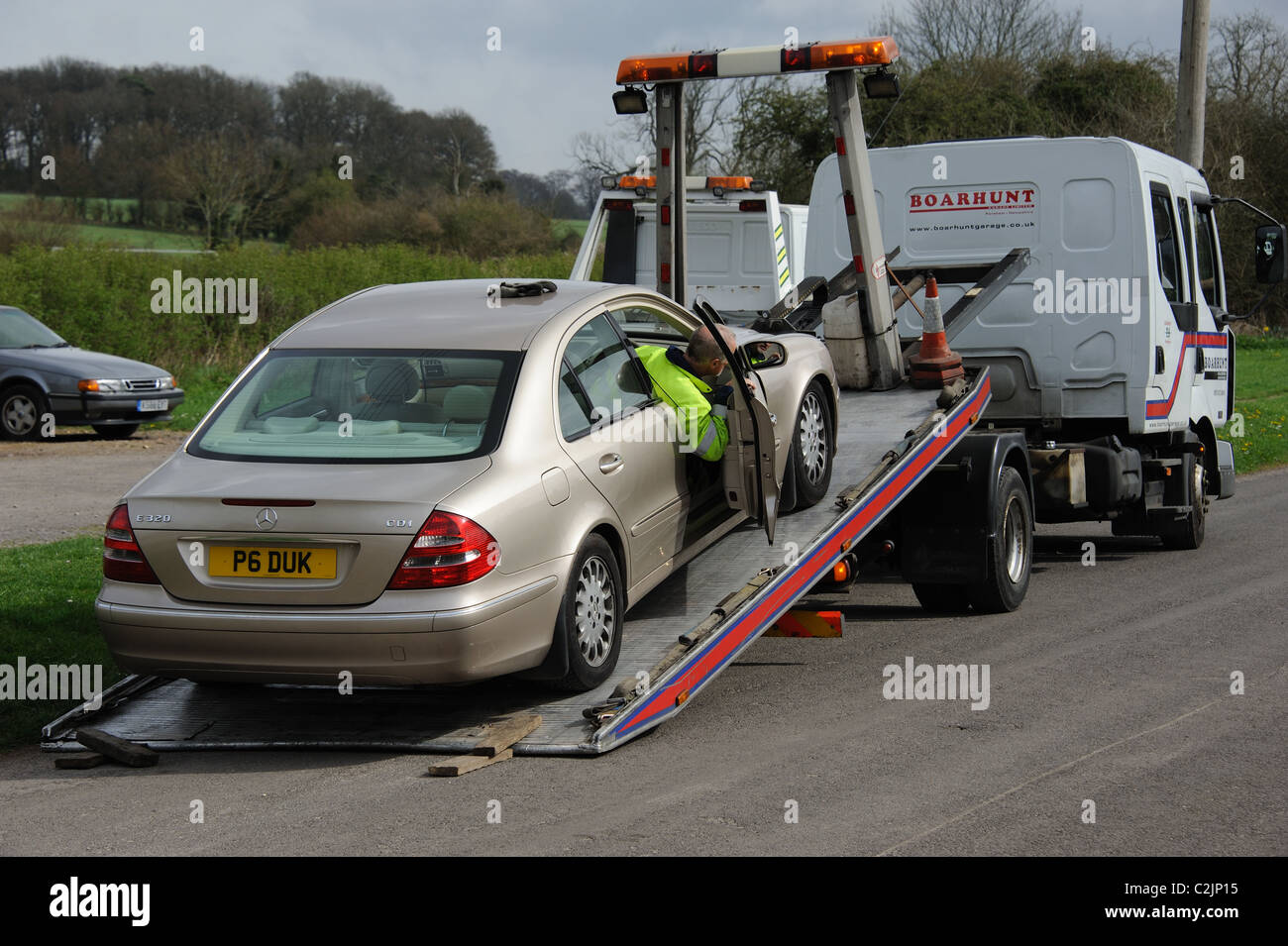 Vehicle roadside recovery truck with a mechanic loading a Mercedes car in Micheldever, Hampshire, UK Stock Photo