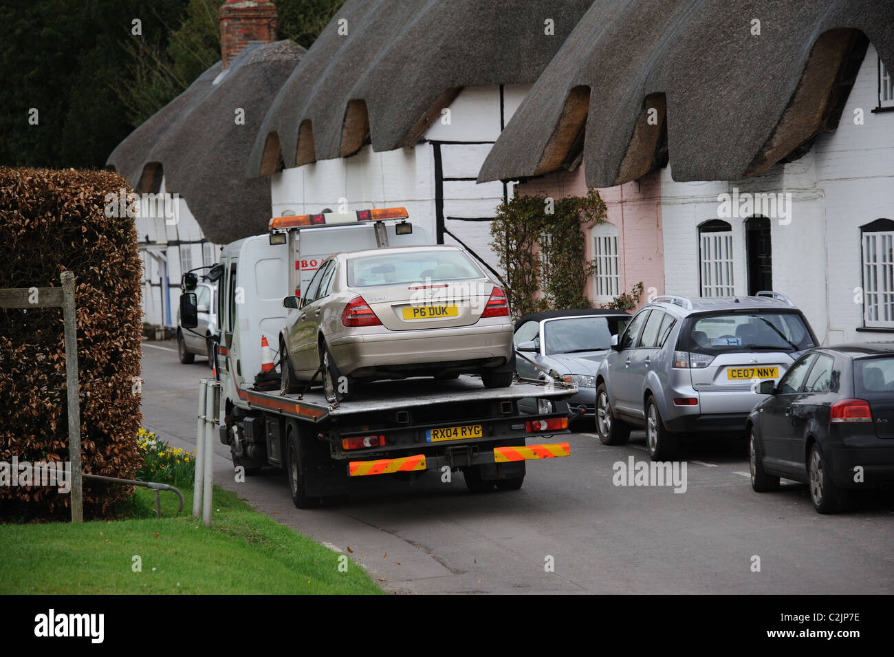 Vehicle recovery truck with a Mercedes car on board passing through Micheldever Hampshire UK Stock Photo