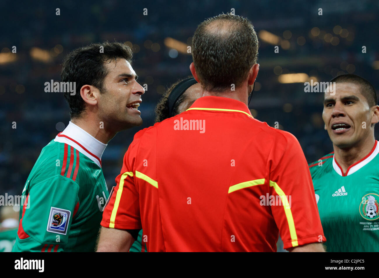 Mexico players Rafael Marquez (l) and Carlos Salcido (r) argue with assistant referee Stefano Ayroldi during a World Cup match. Stock Photo