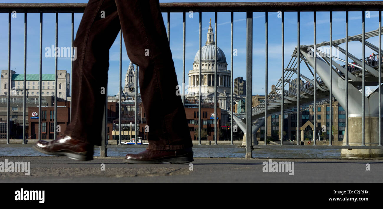Panoramic view of person walking by the Millennium Bridge and St. Paul's Cathedral in the Southbank, London, England, UK Stock Photo