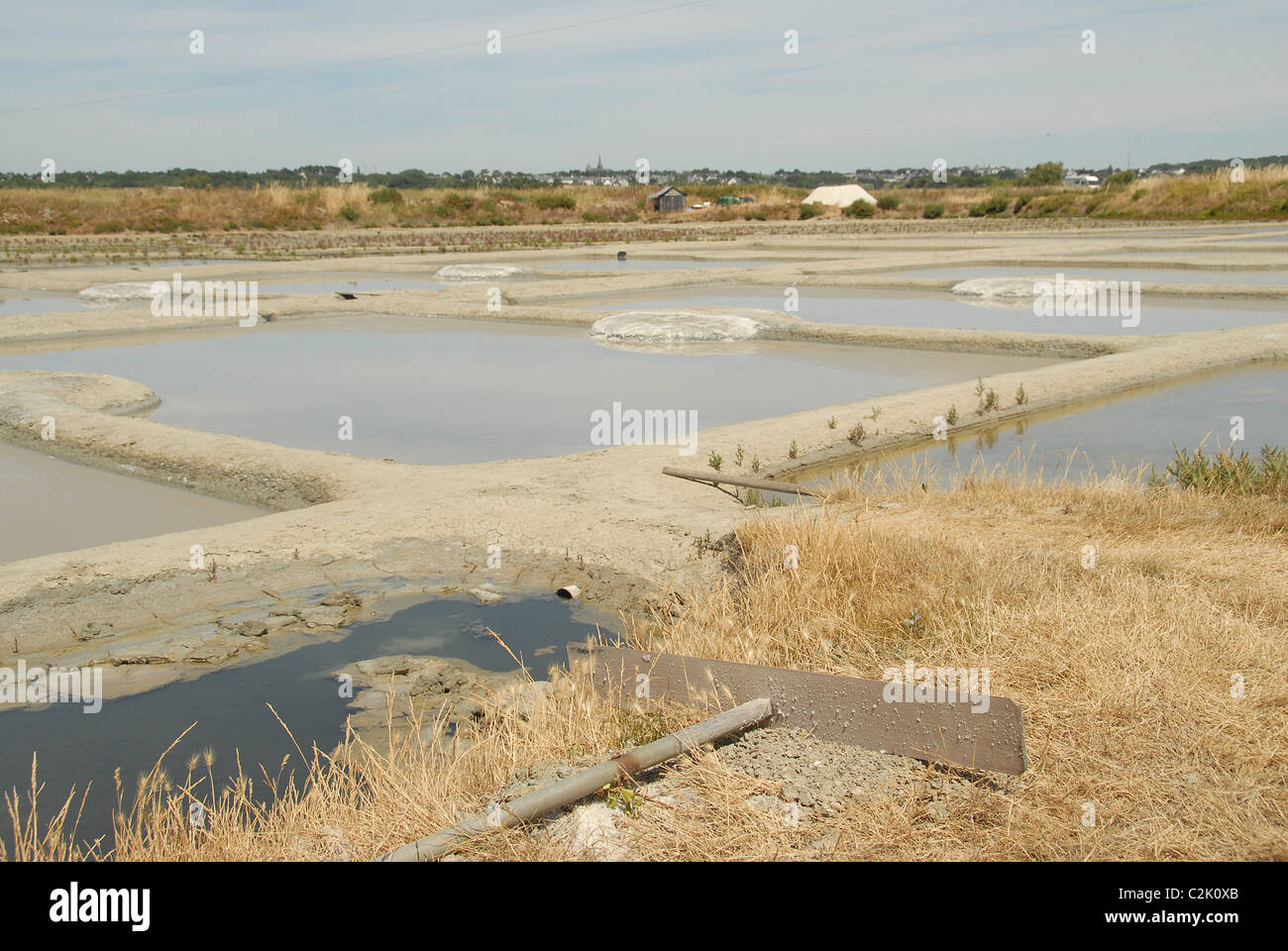 Traditional salt harvesting in the salt marshes (marais salants) between Guérande and Batz-sur-Mer in Loire-Atlantique/France Stock Photo