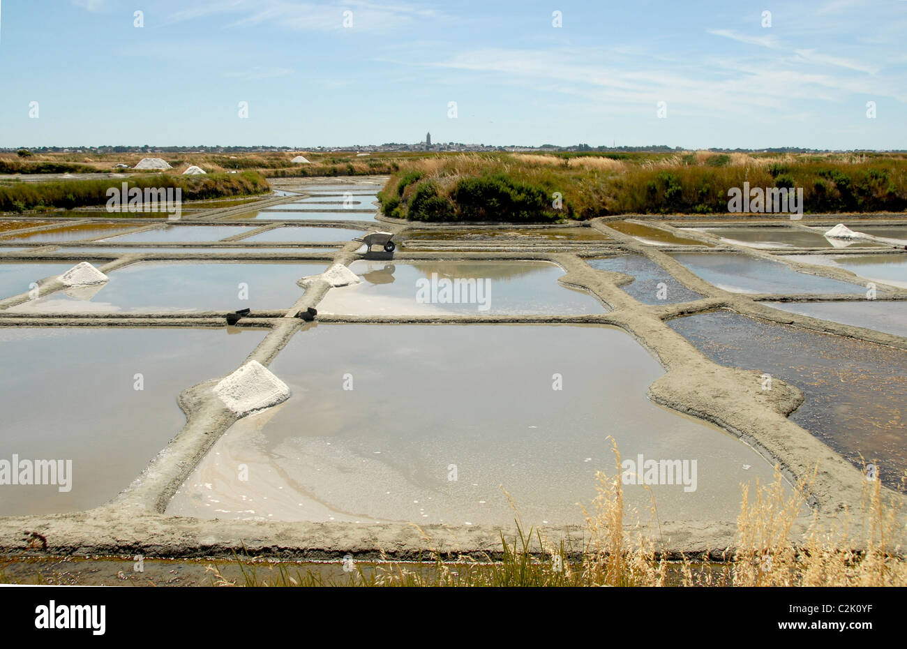 Traditional salt harvesting in the salt marshes (marais salants) between Guérande and Batz-sur-Mer in Loire-Atlantique/France Stock Photo