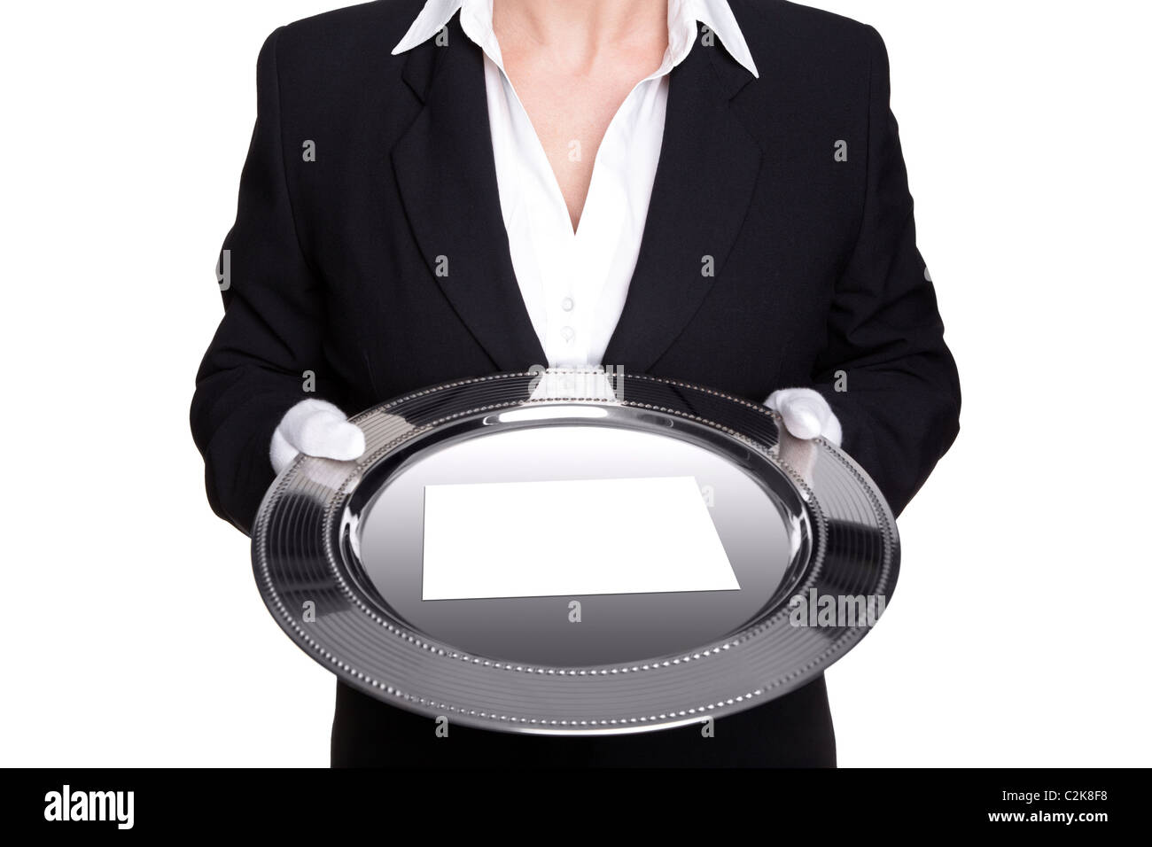 Photo of a female butler holding a silver tray with blank white card, isolated against a white background. Stock Photo