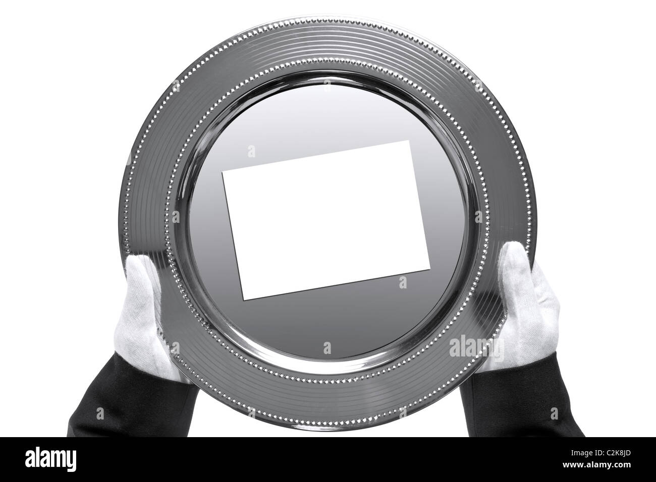 Photo of a silver tray with blank card on being held by a butler, shot from above and isolated on a white background. Stock Photo