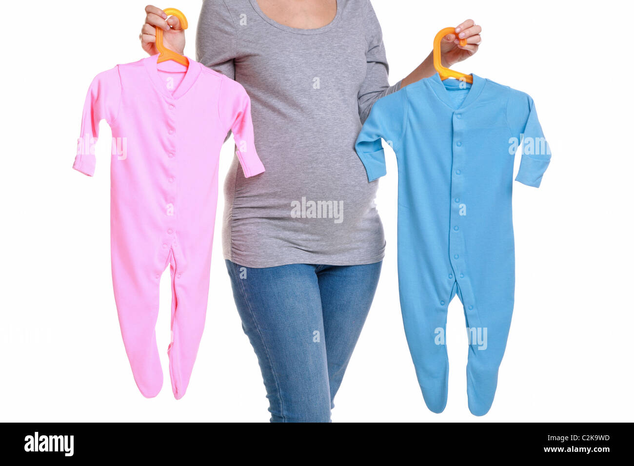 Photo of an attractive brunette woman who is 32 weeks pregnant holding a pink and blue baby grow Stock Photo