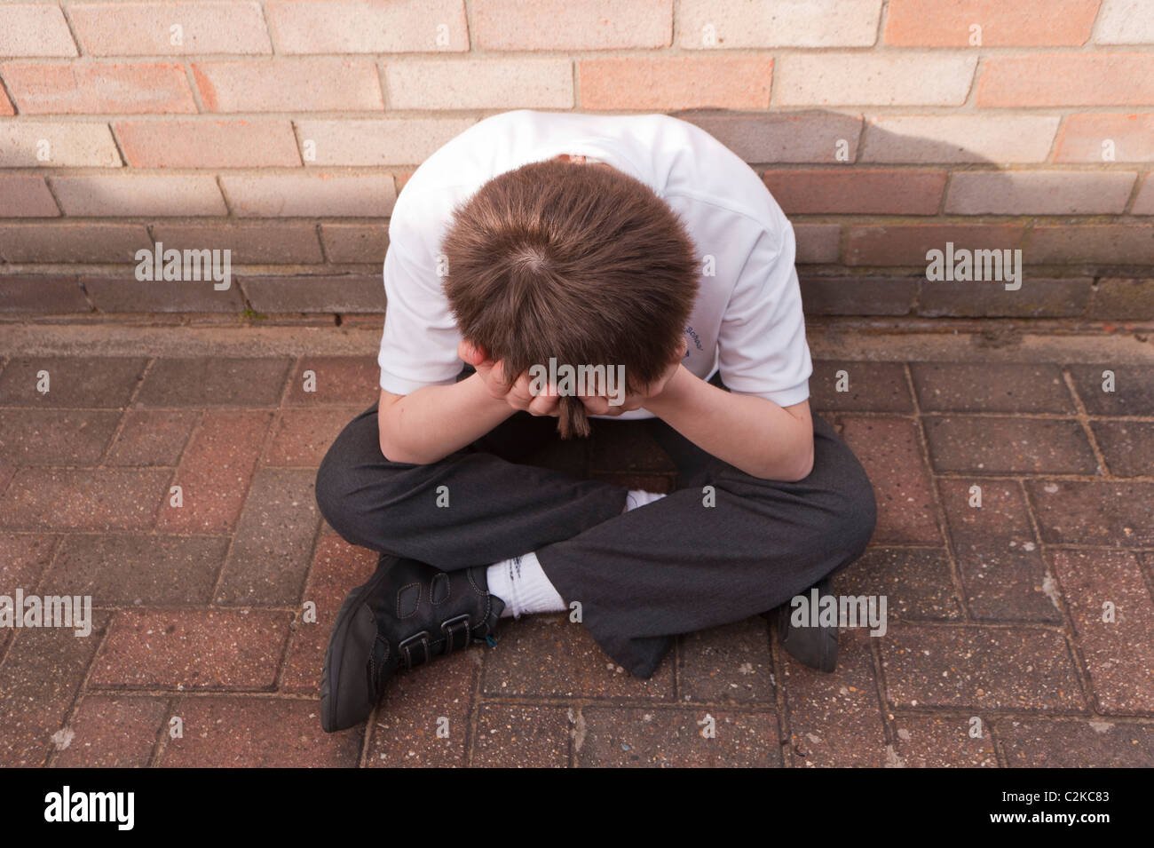 A MODEL RELEASED picture of an eleven year old boy looking depressed outdoors wearing his school uniform in the Uk Stock Photo