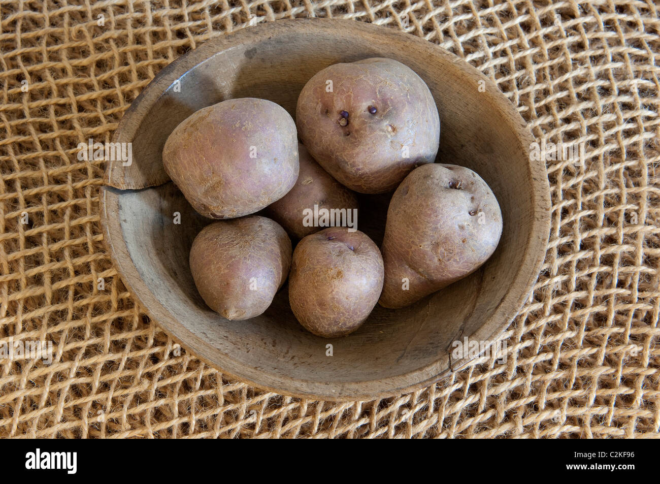 Potato (Solanum tuberosum), variety: Arran Victory. Potatoes in a wooden bowl. Stock Photo