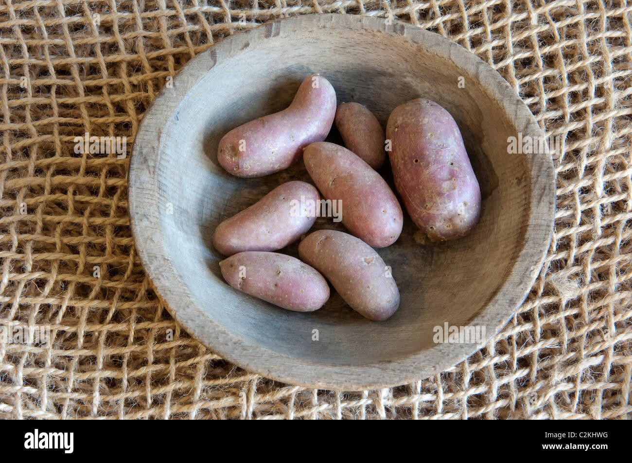 Potato (Solanum tuberosum), variety: Pink Fir Apple. Potatoes a wooden bowl. Stock Photo