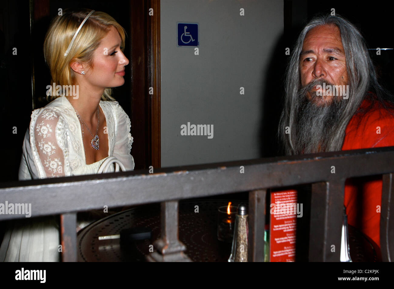 Paris Hilton is seen out with a Shaman who is showing her a book titled 'The Path to the Painted