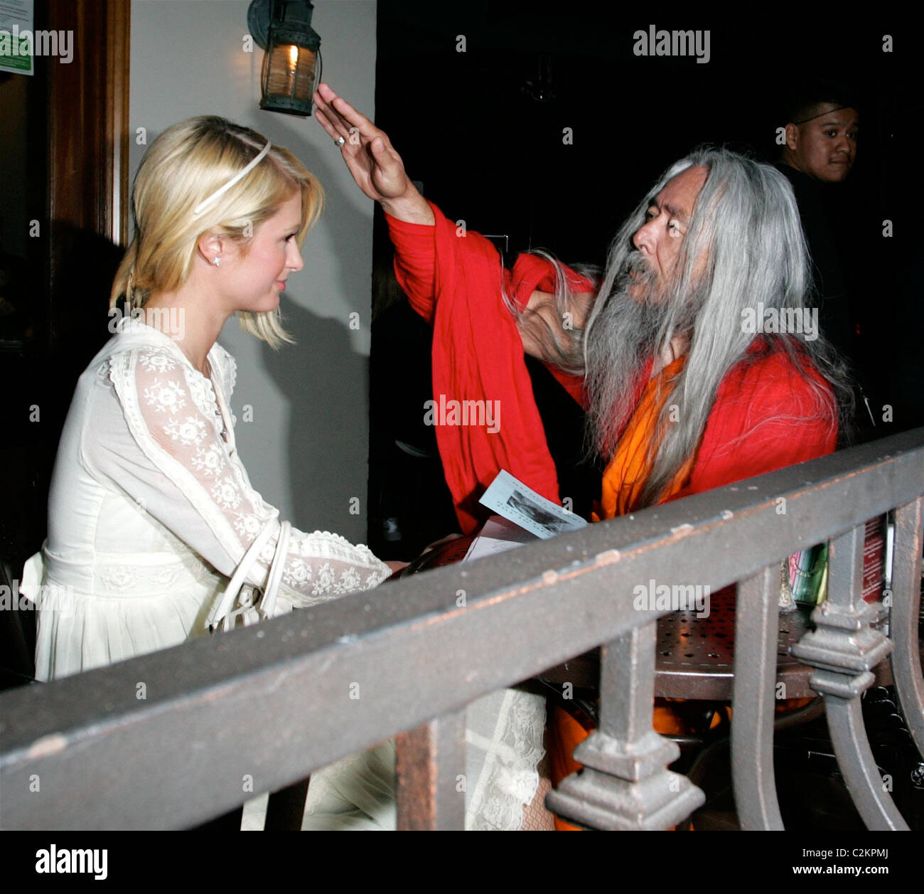 Paris Hilton is seen out with a Shaman who is showing her a book titled 'The Path to the Painted