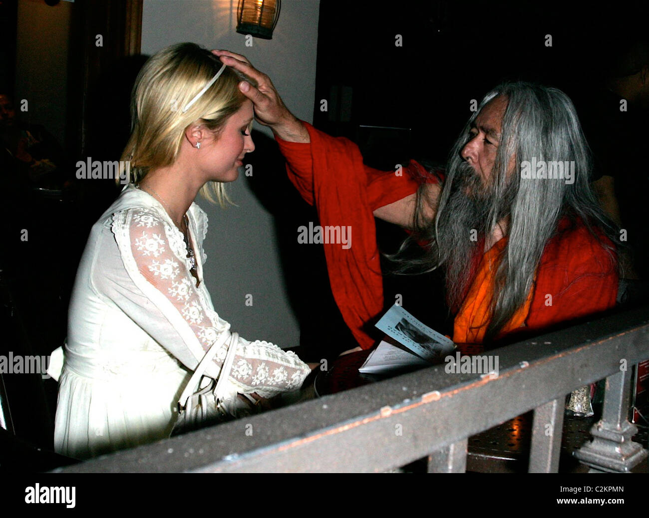 Paris Hilton is seen out with a Shaman who is showing her a book titled 'The Path to the Painted