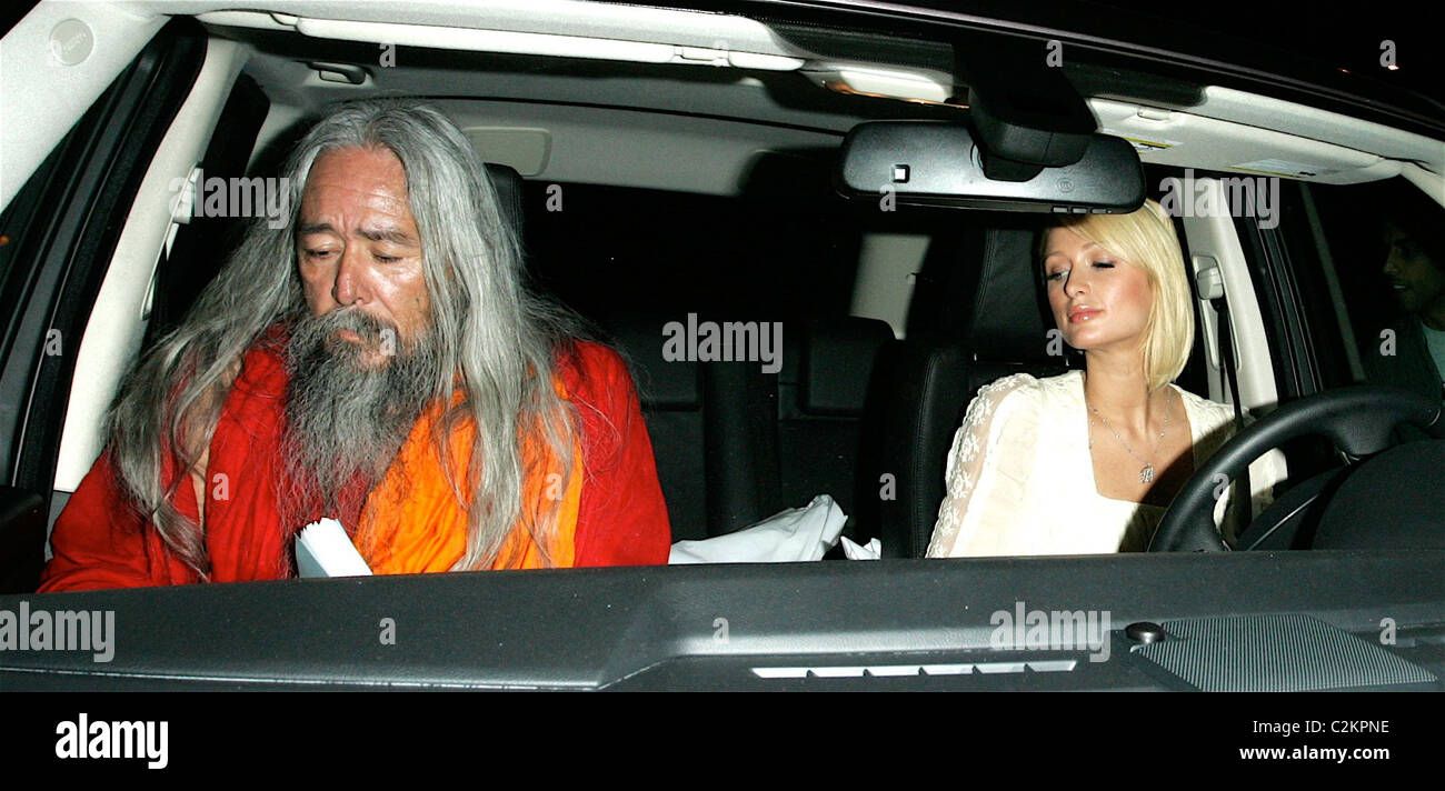 Paris Hilton is seen out with a Shaman who is showing her a book titled 'The Path to the Painted