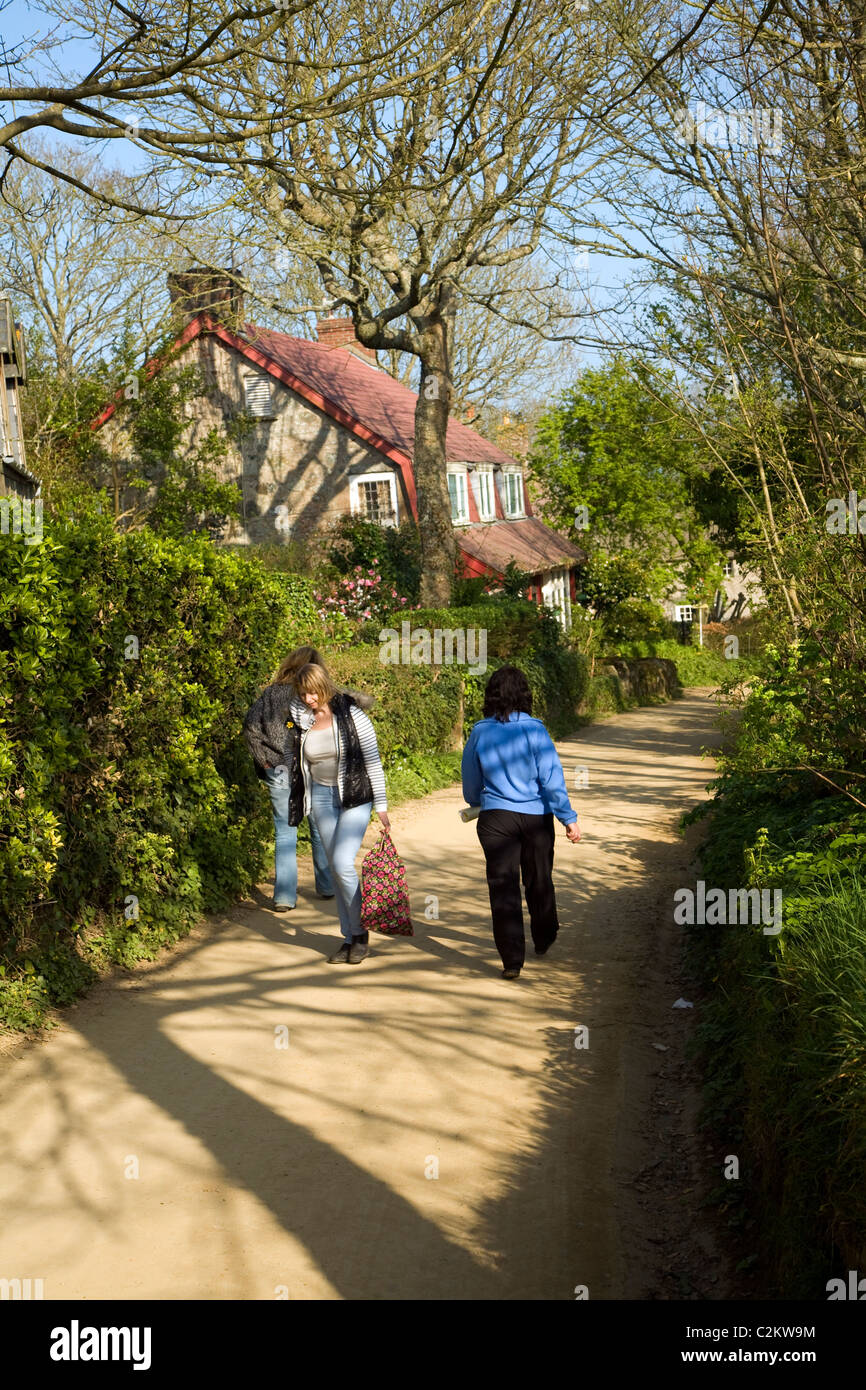 Women walk village street island Sark Channel Islands Stock Photo