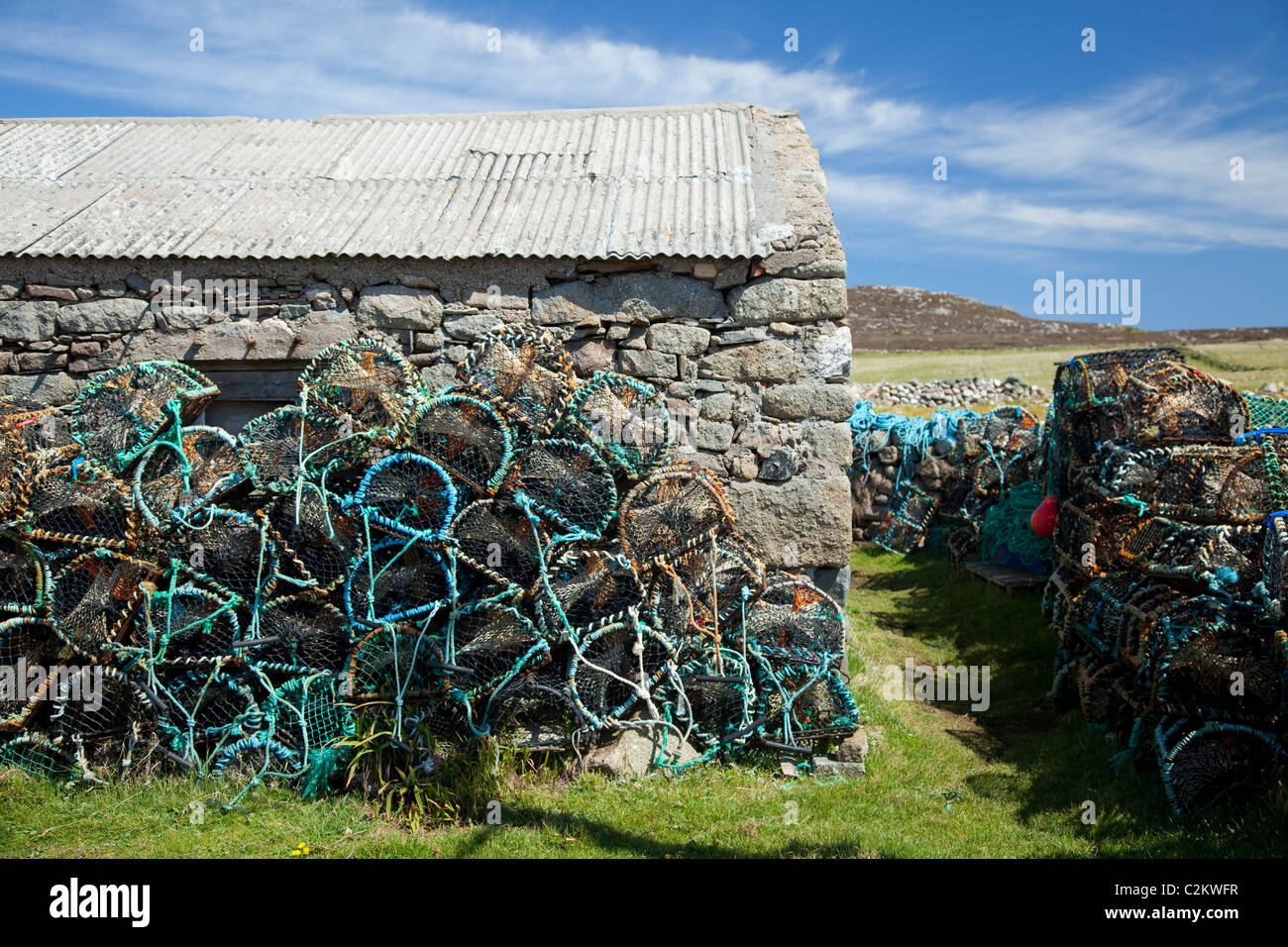Lobster pots stacked beside a shed on Tory Island, County Donegal, Ireland. Stock Photo