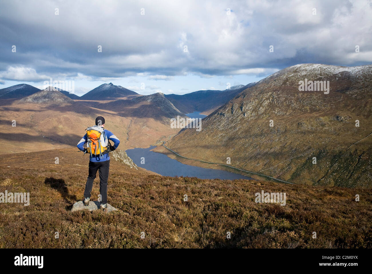 Walker looking along the Silent Valley from Slievenaglogh, Mourne Mountains, County Down, Northern Ireland. Stock Photo