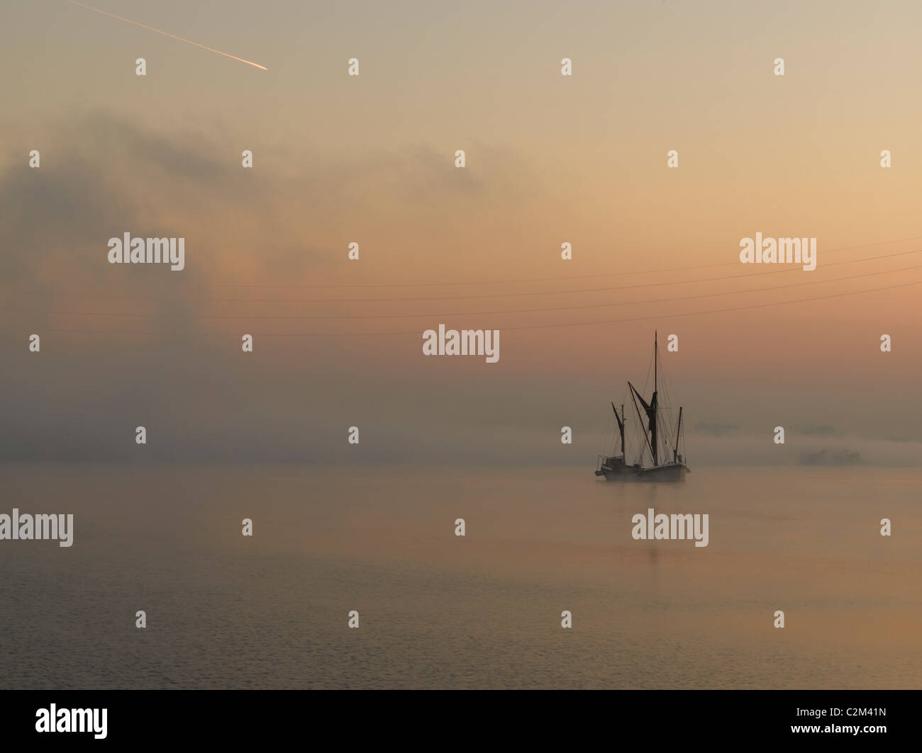 Sailing boat in dawn mist, Thames Estuary, Dartford, London. Stock Photo