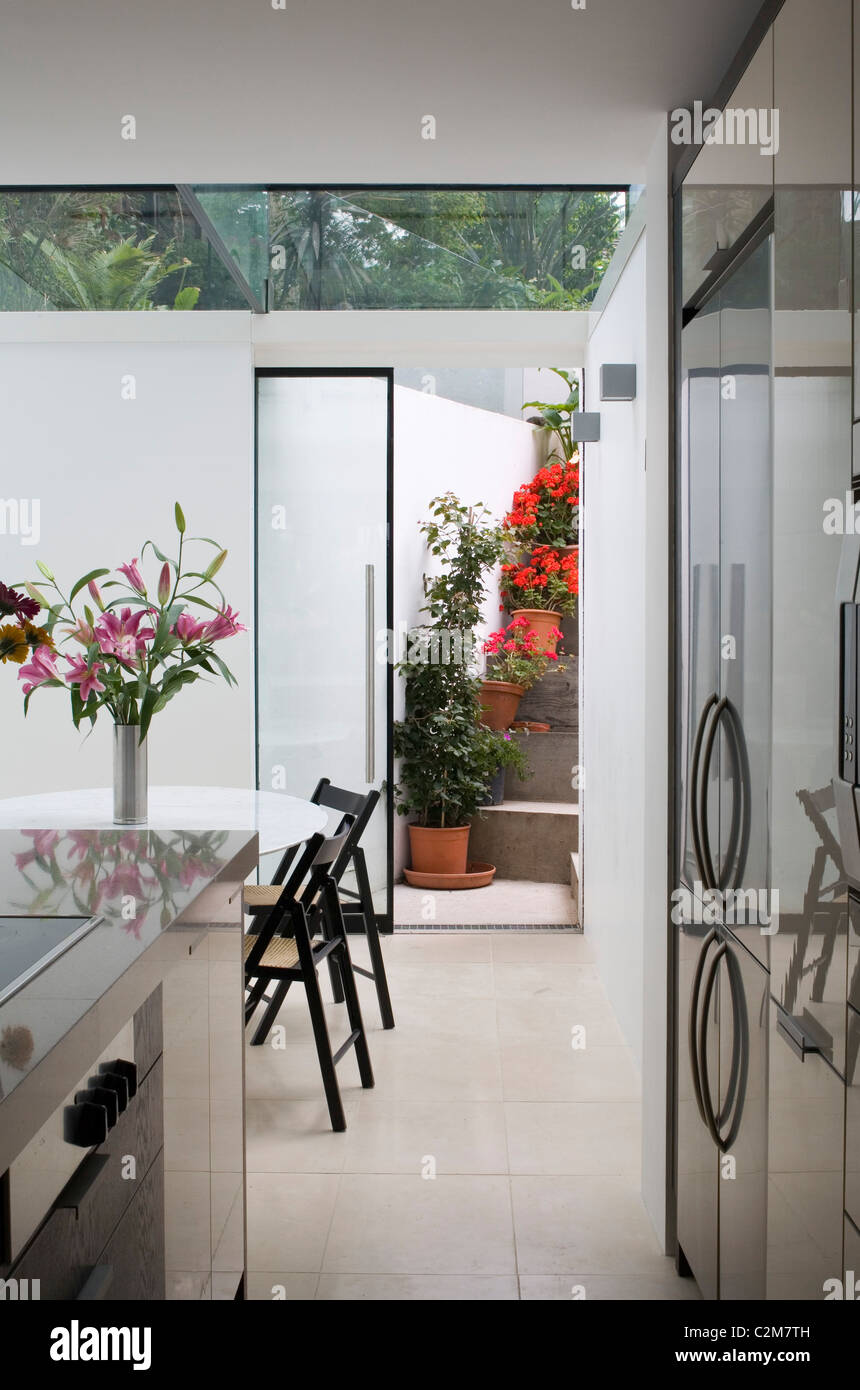 Glass extension, dining table and rear entrance. Stock Photo