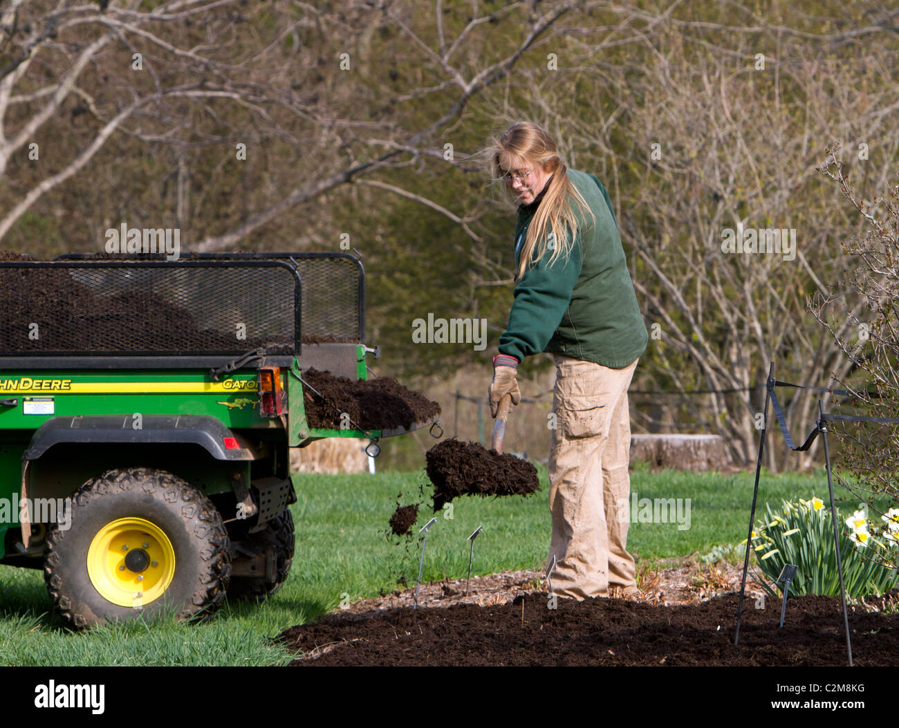 Spreading mulch in the garden with a John Deere Gator TX and a