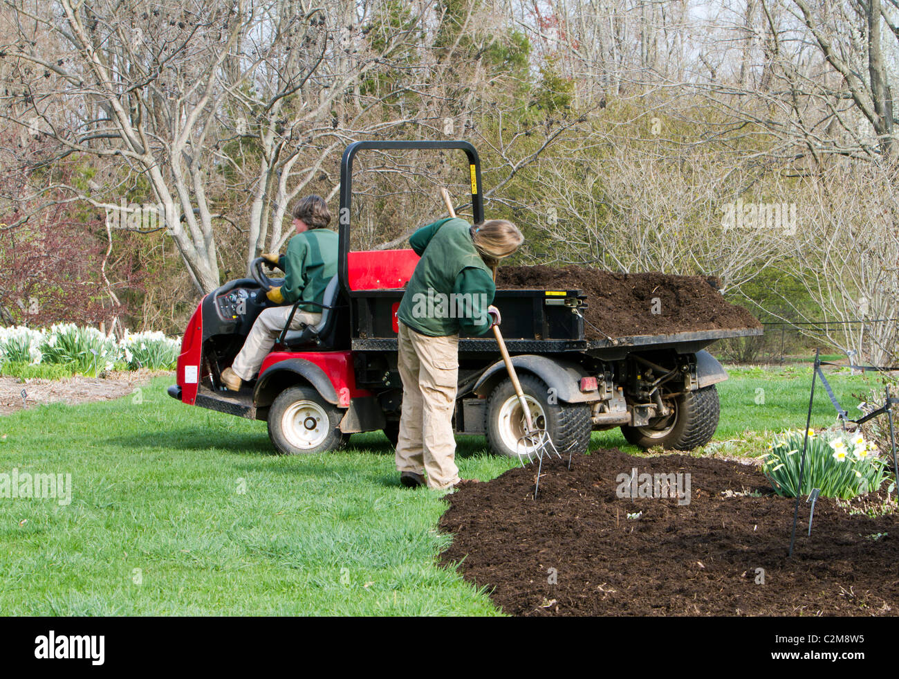 Spreading mulch in a flower bed with a Toro Workman utility vehicle and