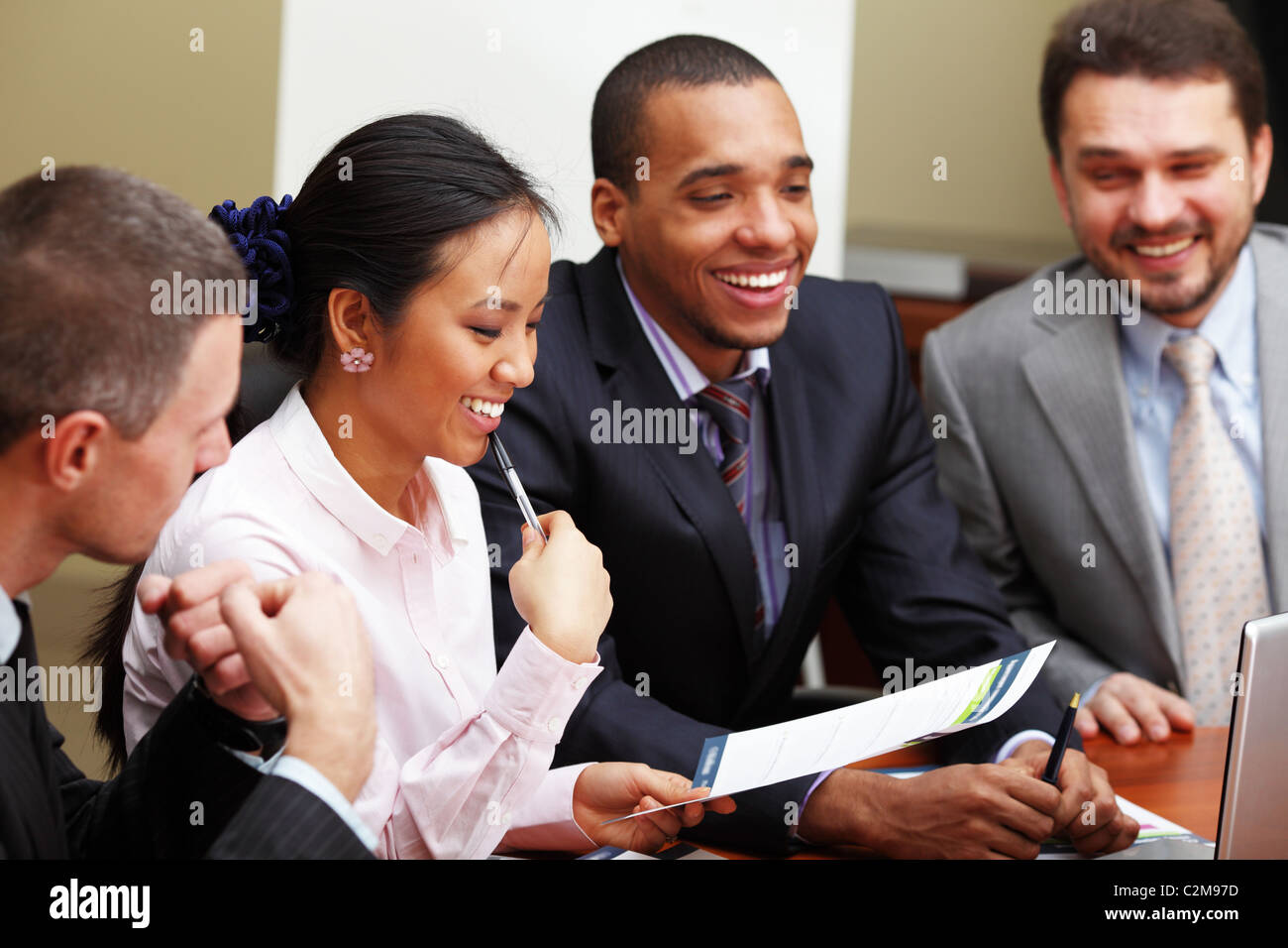 Multi ethnic business team at a meeting. Interacting. Focus on woman Stock Photo