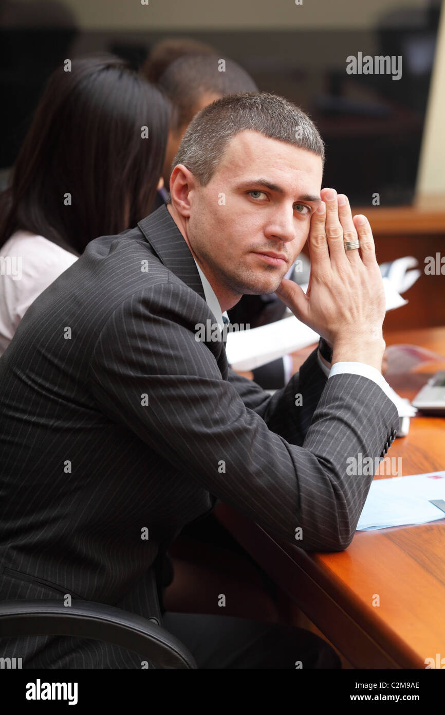 Serious mature businessman in business meeting at office, looking at ...