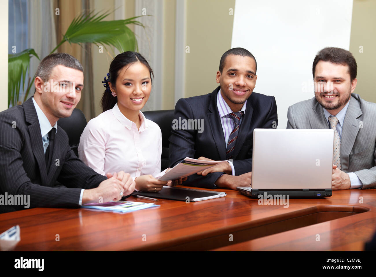 Multi ethnic business team at a meeting. Interacting. Focus on african-american man Stock Photo