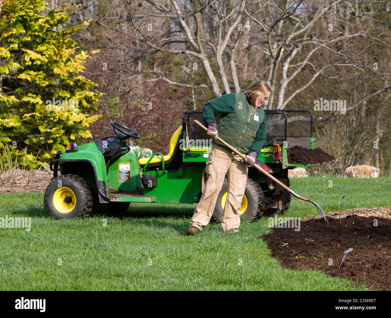 Spreading mulch in the garden with a John Deere Gator TX and a
