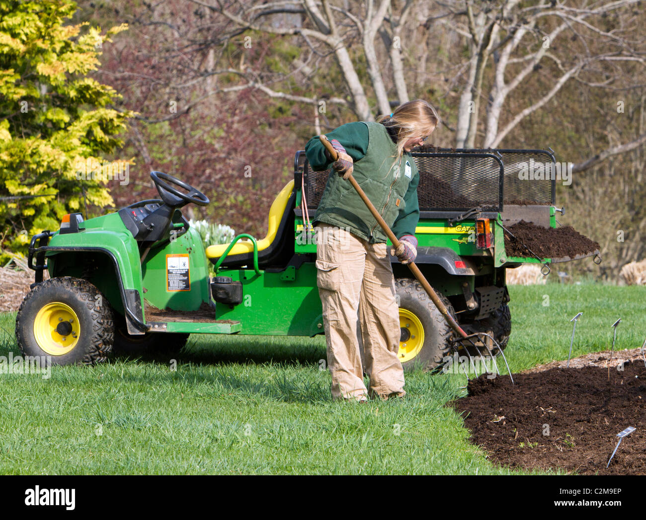 Spreading mulch in the garden with a John Deere Gator TX and a