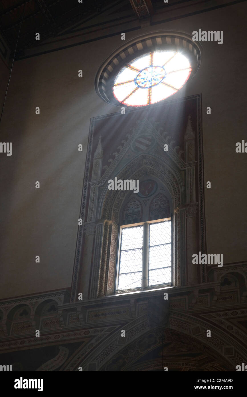 Rays of light burst through a circular stained glass window. . Stock Photo