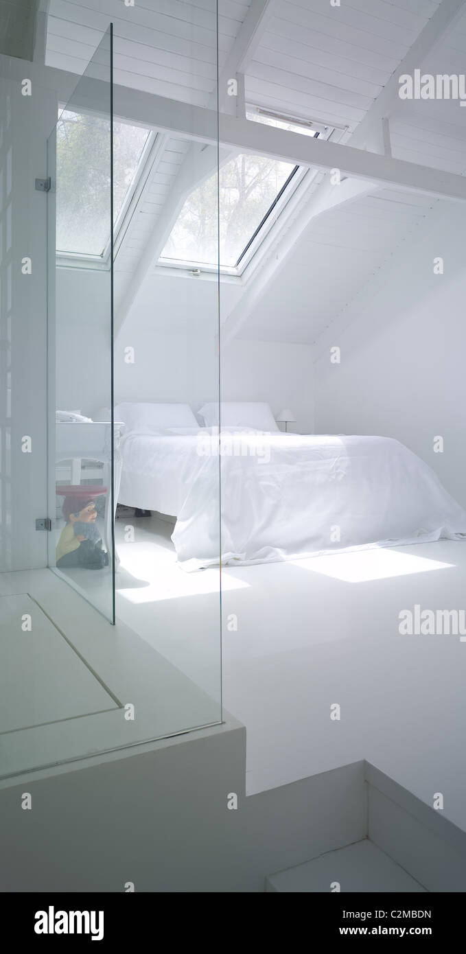 Modern white bedroom under eaves and behind glass walls Stock Photo Alamy