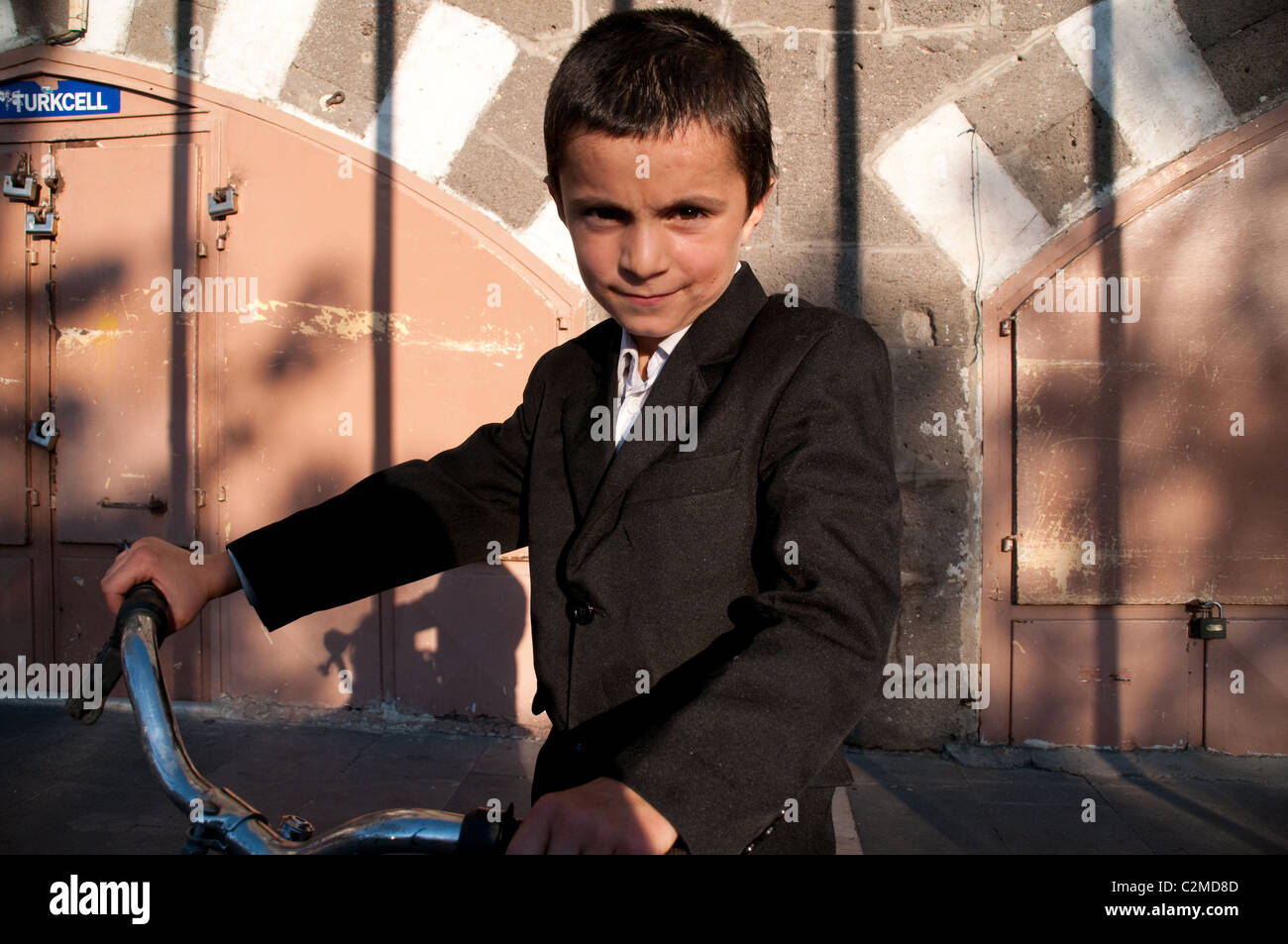 A portrait of a young Kurdish boy with his bicycle in the old quarter