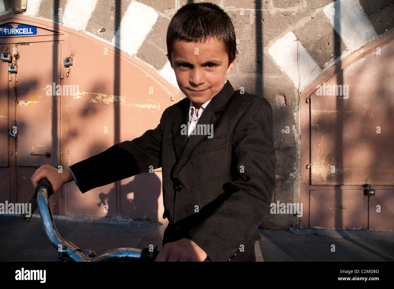 A portrait of a young Kurdish boy with his bicycle in the old quarter of the city of Diyarbakir in eastern Anatolia region of southeast Turkey. Stock Photo