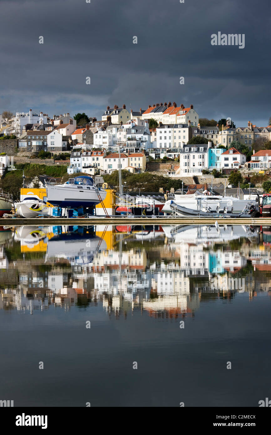 St Peter Port and harbour side boats stored on dry dock reflected in a model boat pond in Guernsey, Channel Islands, UK Stock Photo