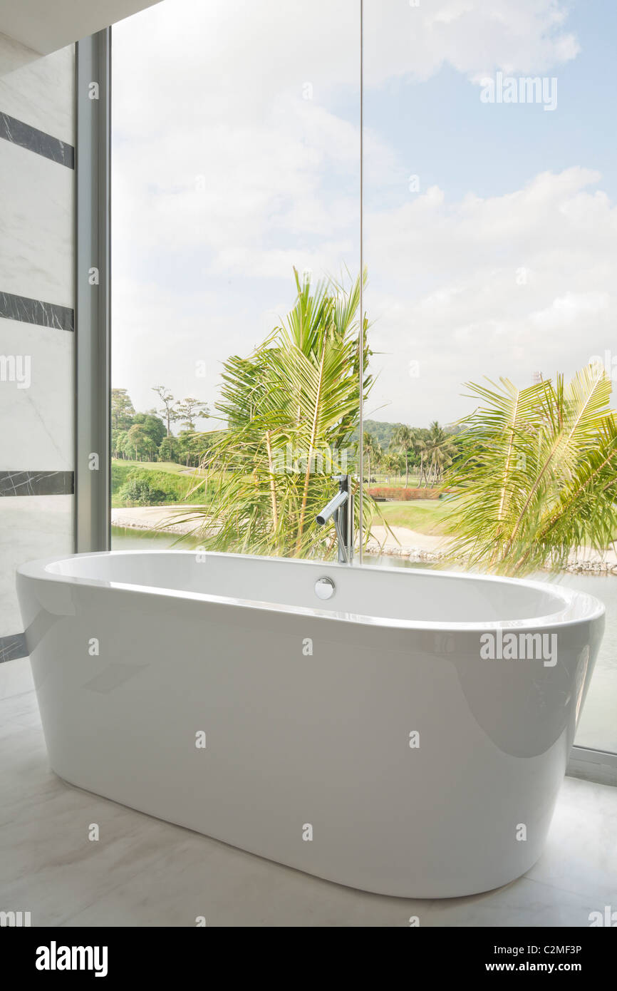 Modern ceramic bathtub and glass picture windows with view Stock Photo