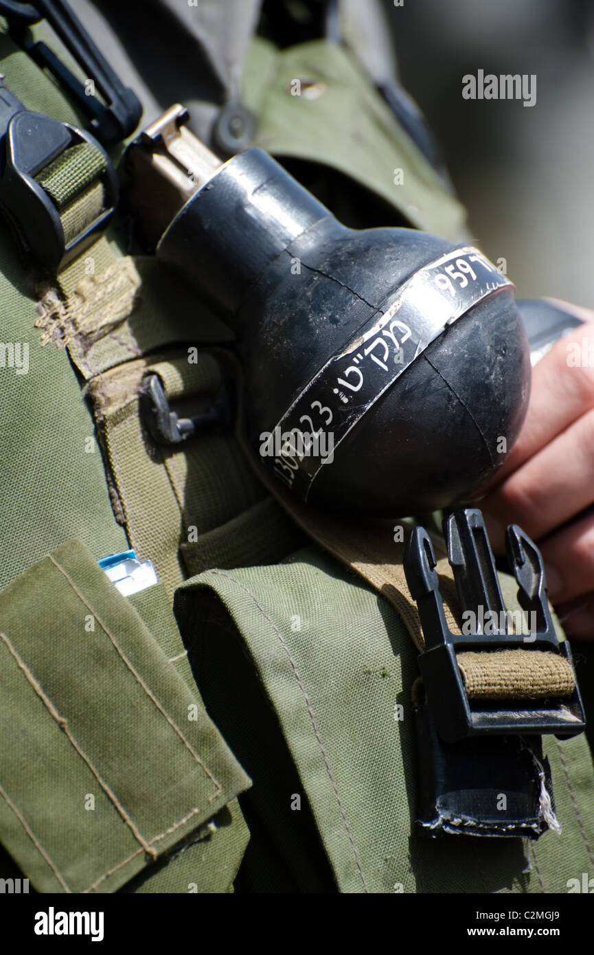 A "rubber ball" grenade is clipped to the uniform of an Israeli soldier