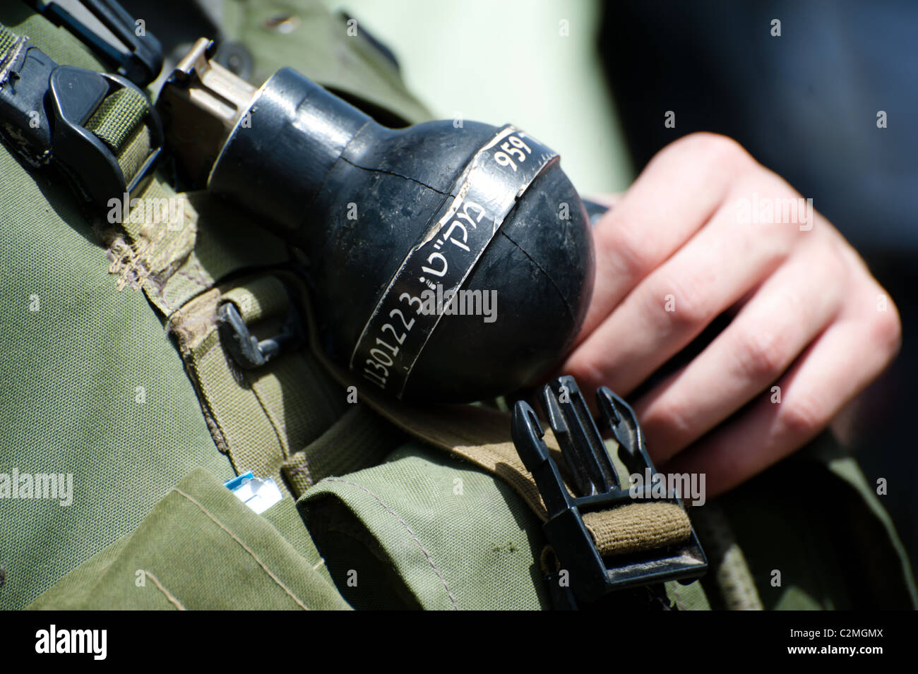 A "rubber ball" grenade is clipped to the uniform of an Israeli soldier